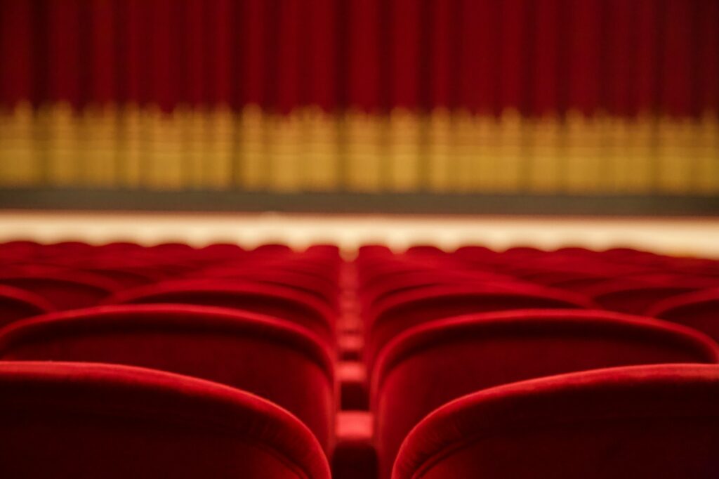 Red theater seats looking up at a stage in the background